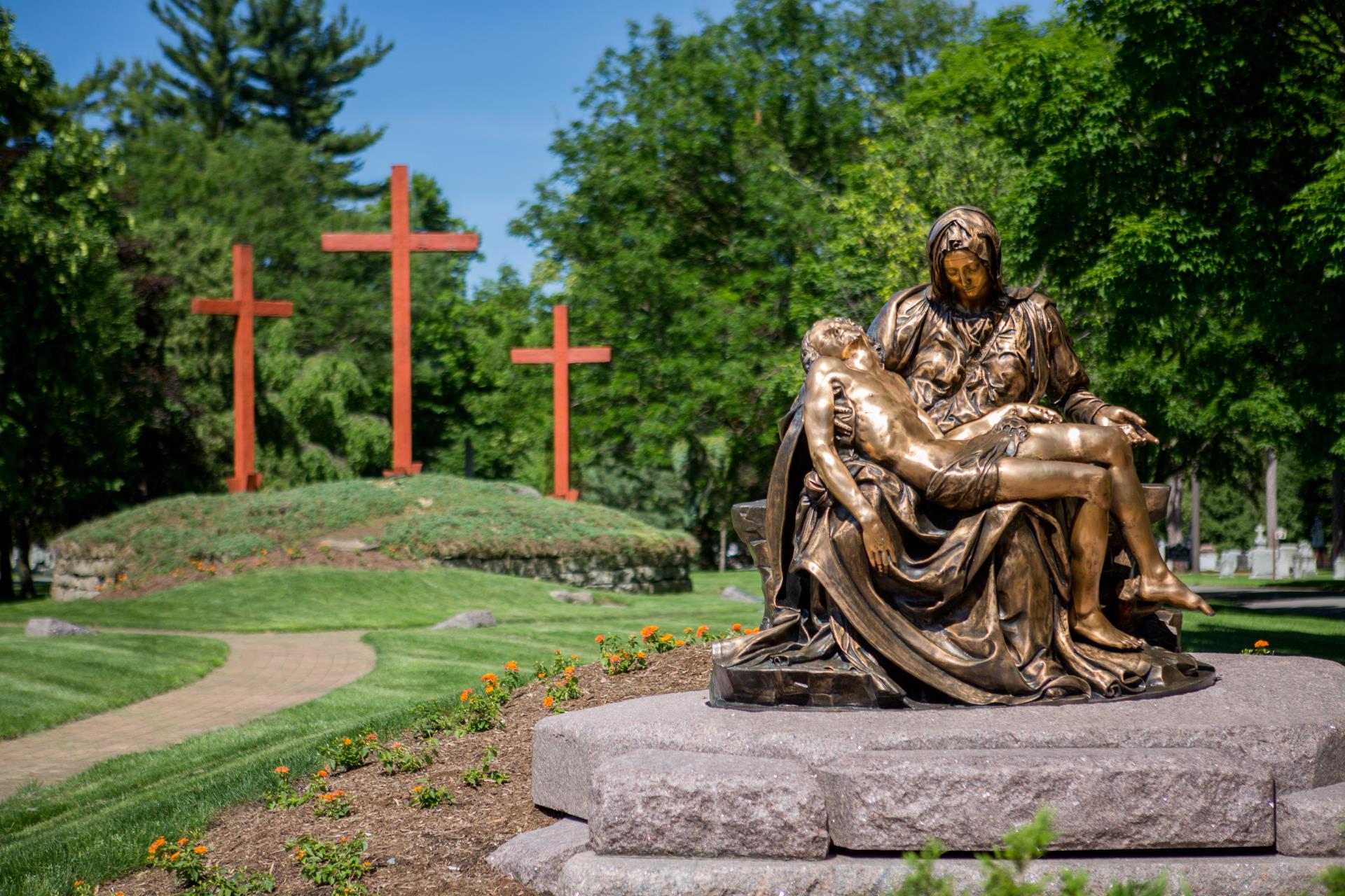 Pieta monument in front of 3 crosses