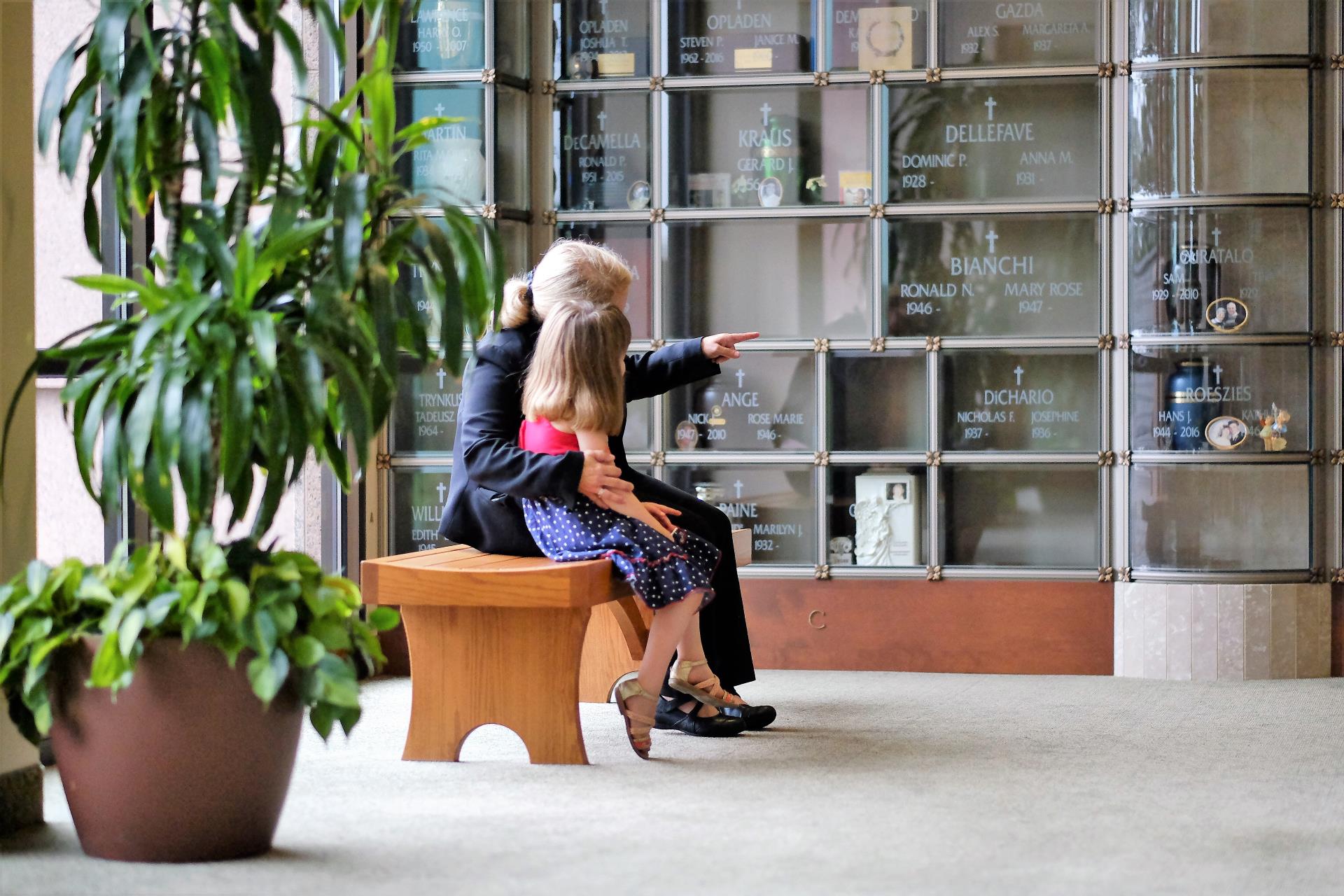 woman and child in front of glass front niches